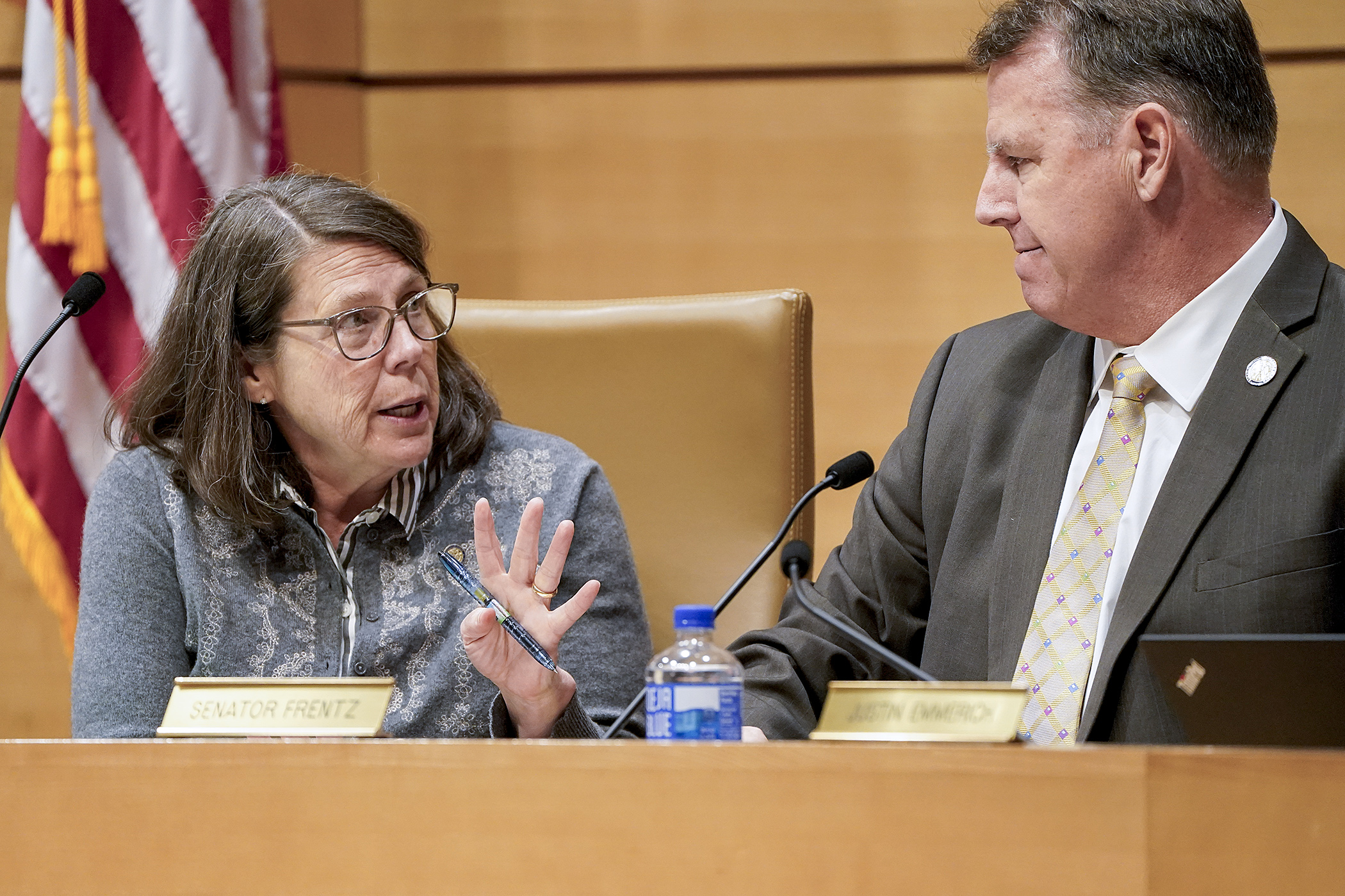 Rep. Patty Acomb and Sen. Nick Frentz confer May 14 before convening the agriculture, commerce, energy, utilities, environment and climate conference committee. (Photo by Michele Jokinen)